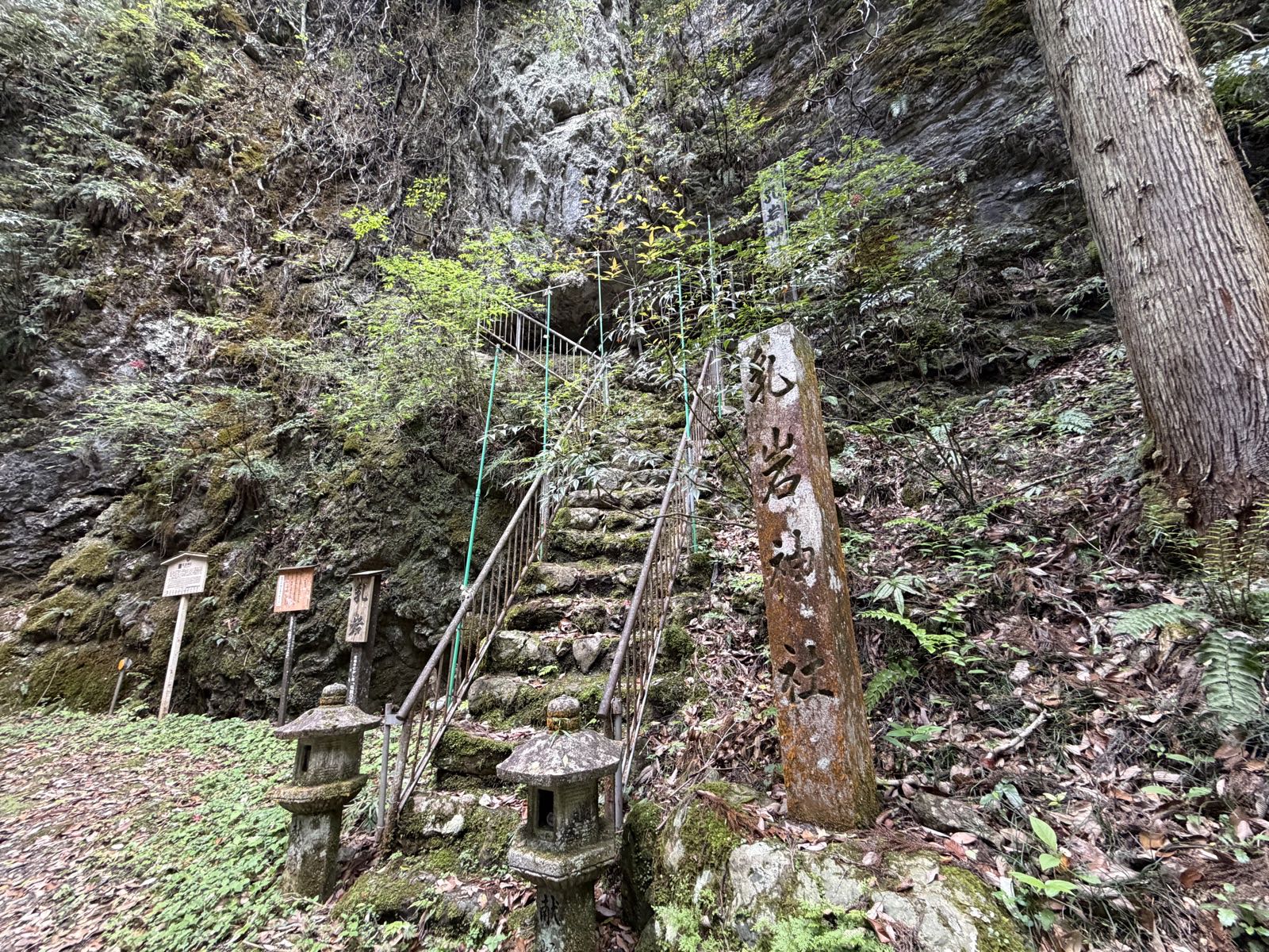 乳岩神社の社号標と、岩壁に向かって続く石段